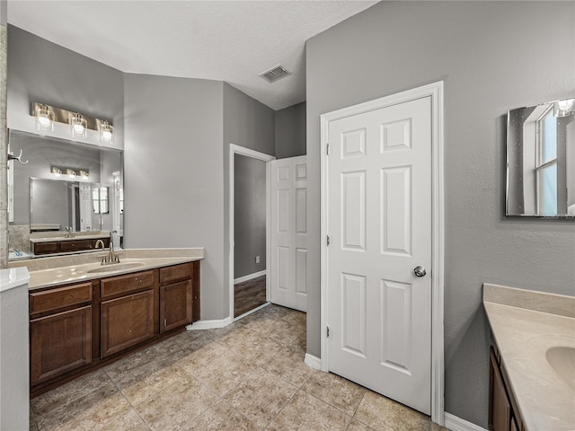 bathroom featuring a textured ceiling and vanity