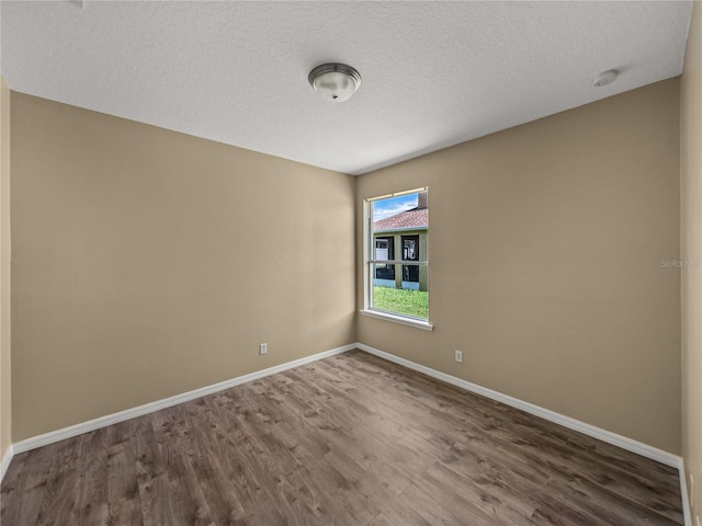 spare room with a textured ceiling and hardwood / wood-style flooring