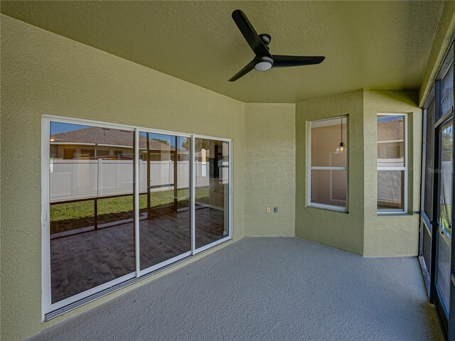 unfurnished sunroom with ceiling fan