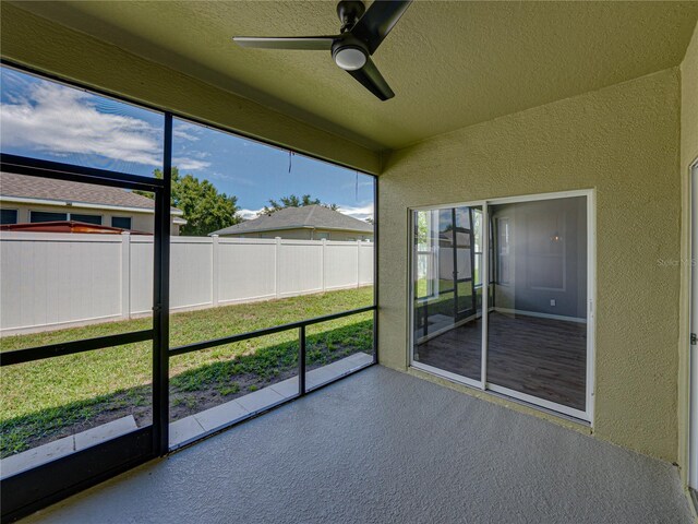 unfurnished sunroom featuring ceiling fan