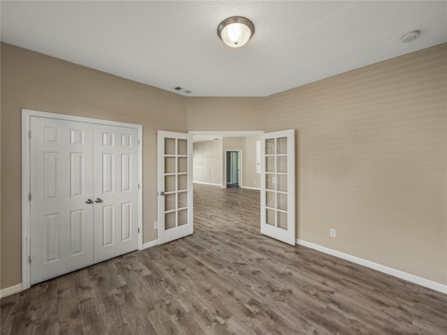 interior space with hardwood / wood-style floors, french doors, and a textured ceiling