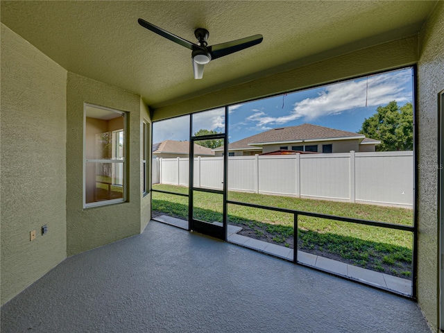 unfurnished sunroom with ceiling fan