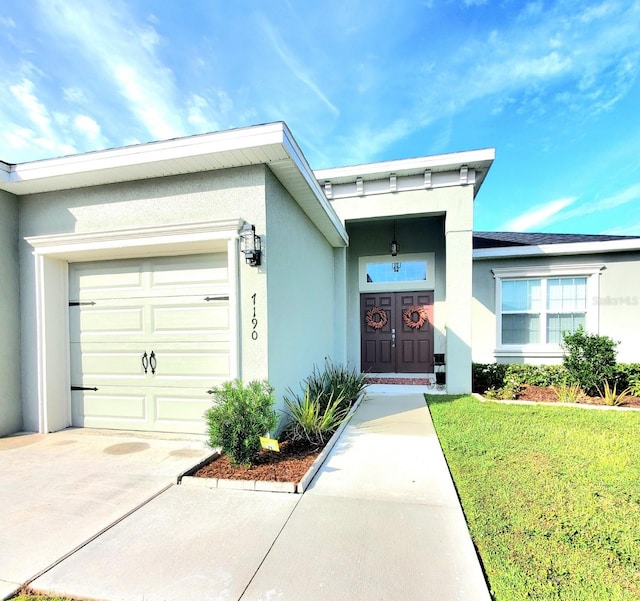 property entrance with a garage and a lawn