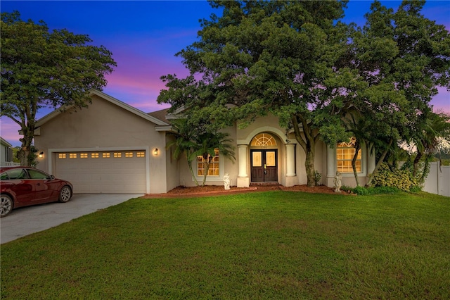 view of front facade featuring a lawn and a garage