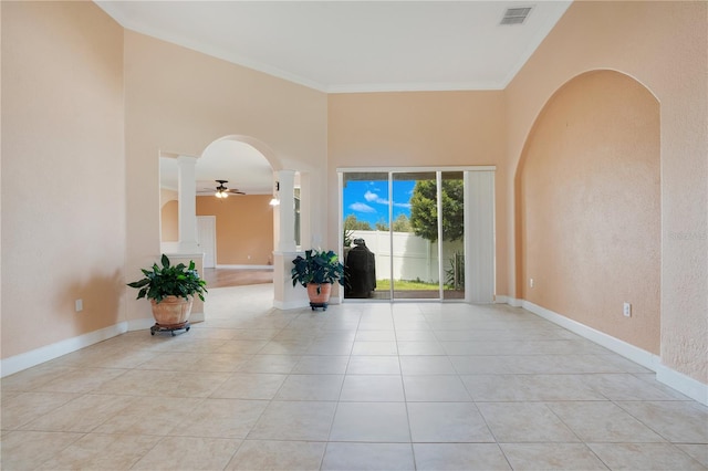 tiled spare room with ornamental molding and ceiling fan