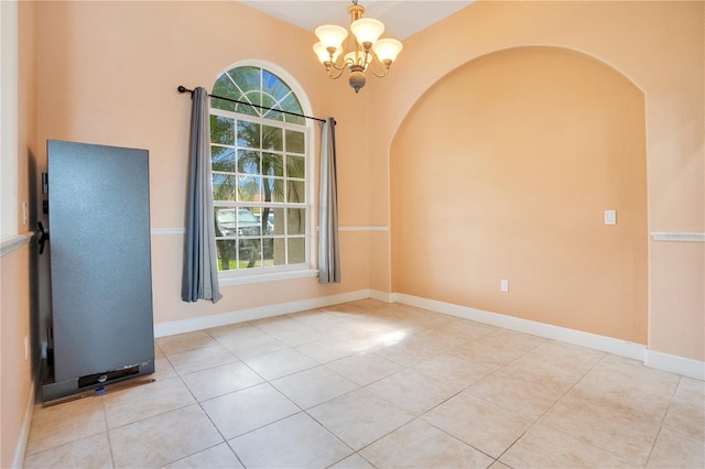 spare room with light tile patterned floors and a chandelier