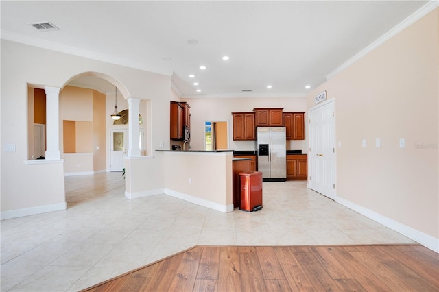 kitchen featuring ornamental molding, appliances with stainless steel finishes, decorative columns, and light hardwood / wood-style floors