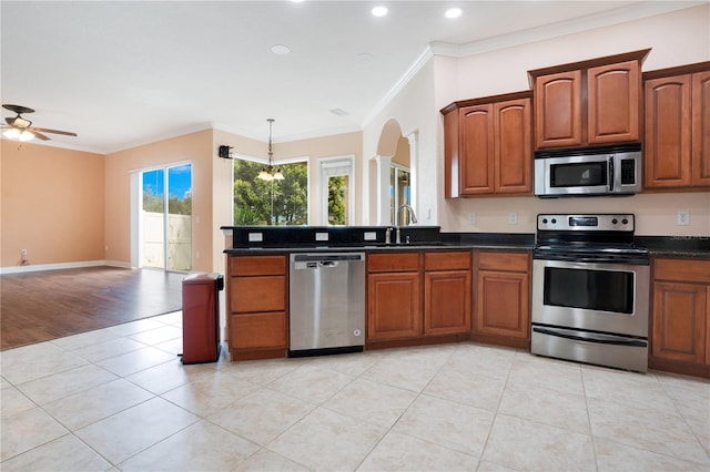 kitchen featuring light hardwood / wood-style flooring, ceiling fan with notable chandelier, stainless steel appliances, and a healthy amount of sunlight