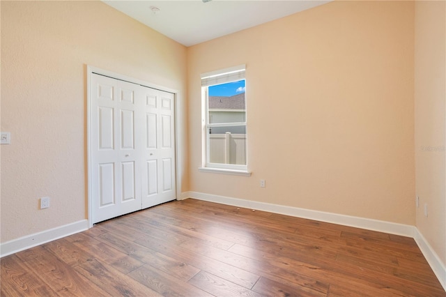 unfurnished bedroom with wood-type flooring and a closet