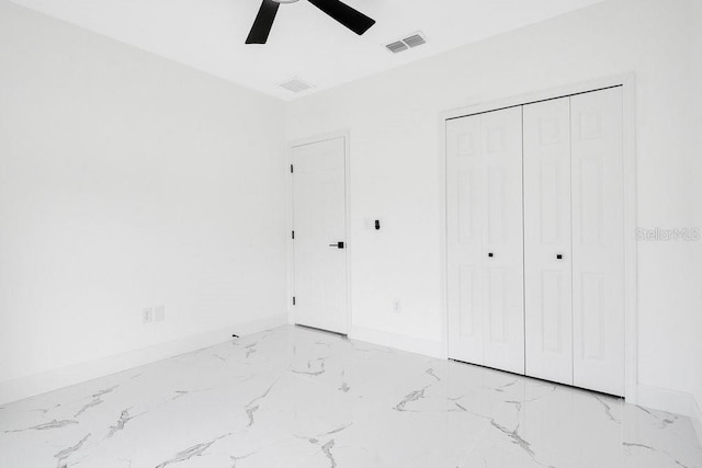 unfurnished bedroom with ceiling fan and a closet