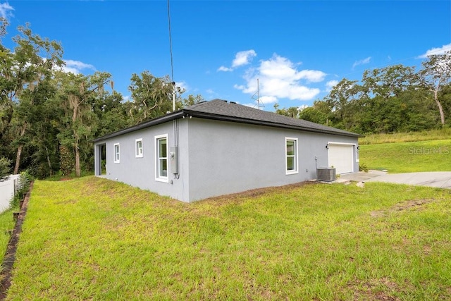 view of side of home featuring central air condition unit and a lawn