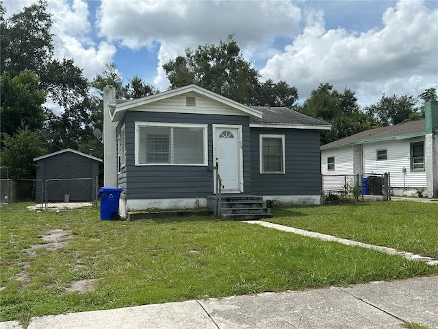 bungalow with a storage shed and a front yard