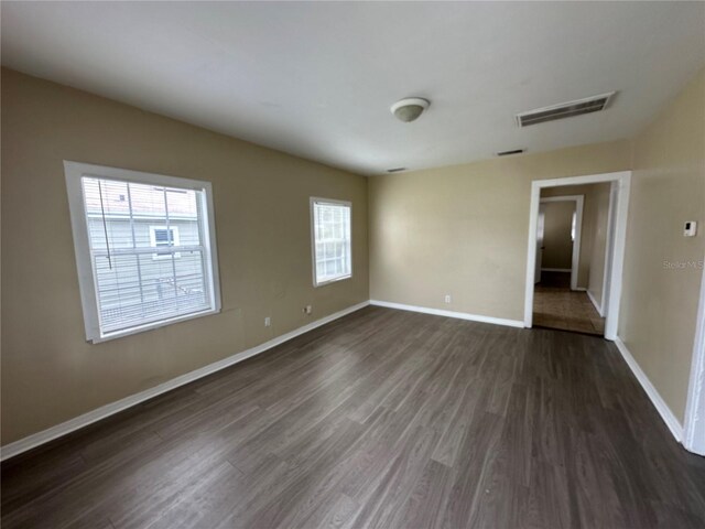 unfurnished room featuring dark wood-type flooring