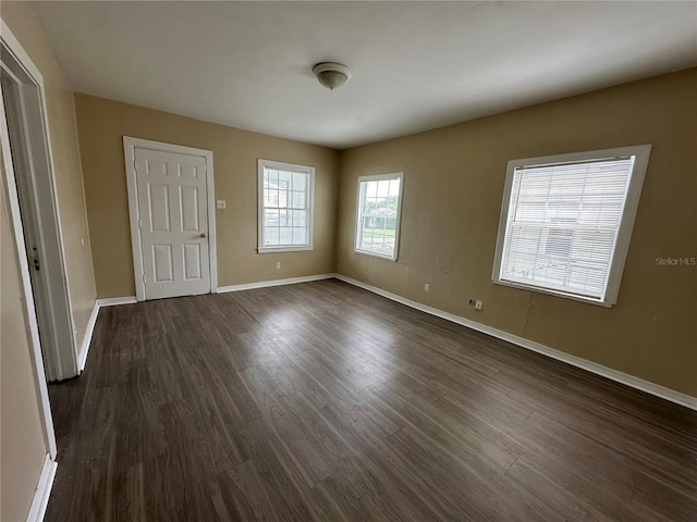 spare room featuring dark wood finished floors and baseboards