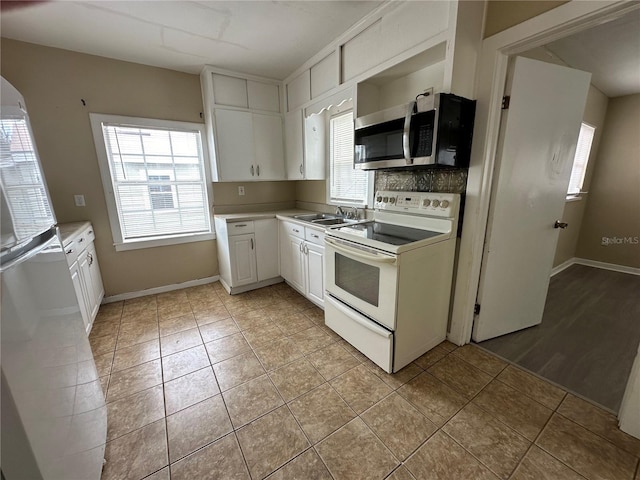 kitchen featuring white cabinets, hardwood / wood-style floors, white appliances, sink, and decorative backsplash