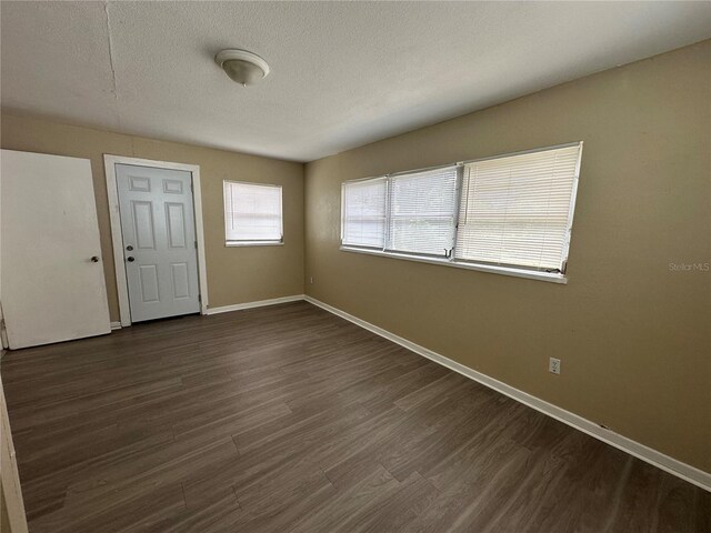 entryway featuring dark wood-type flooring and a textured ceiling