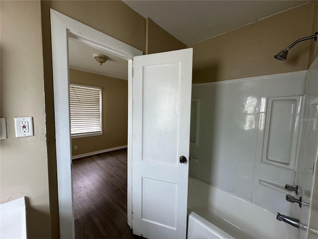 bathroom with washtub / shower combination and hardwood / wood-style flooring