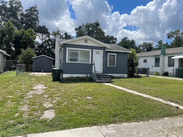 view of front of house with a front lawn and a shed