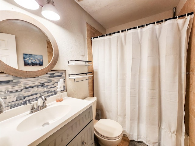 bathroom featuring walk in shower, backsplash, vanity, and toilet