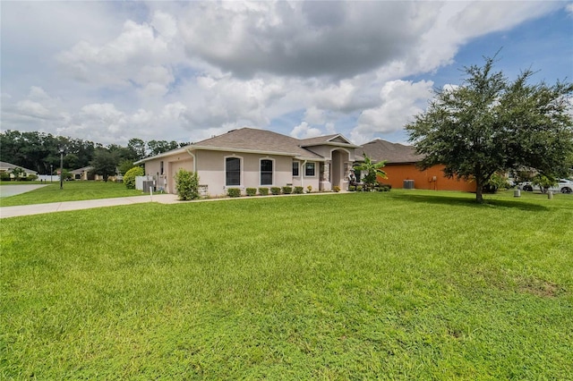 view of front of property with an attached garage, driveway, a front yard, and stucco siding