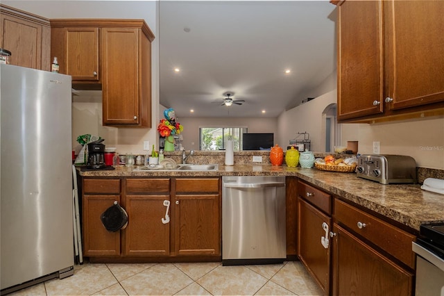 kitchen featuring light tile patterned floors, vaulted ceiling, appliances with stainless steel finishes, sink, and ceiling fan