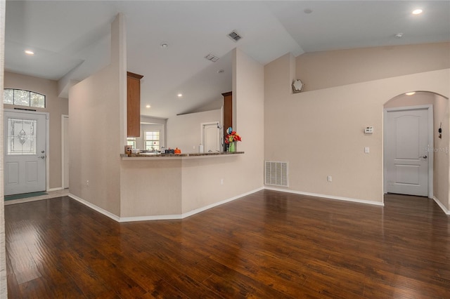 unfurnished living room with dark wood-type flooring and high vaulted ceiling