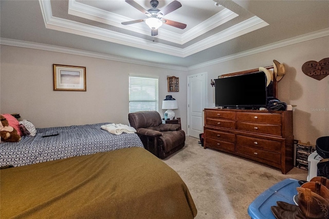 bedroom with ornamental molding, a tray ceiling, ceiling fan, and carpet flooring