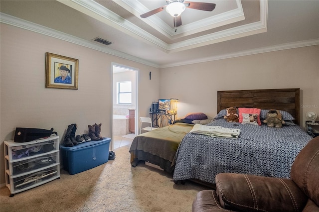 carpeted bedroom featuring crown molding, ceiling fan, a raised ceiling, and ensuite bath