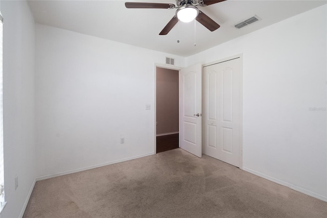 interior space featuring light carpet, ceiling fan, and a closet