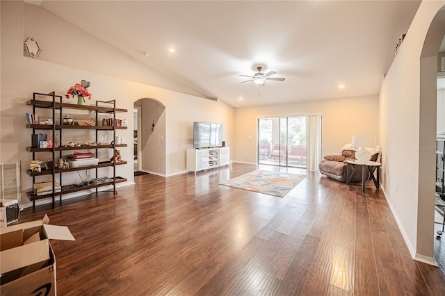 living area with ceiling fan, arched walkways, vaulted ceiling, and wood finished floors