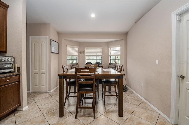 dining space with light tile patterned floors and baseboards