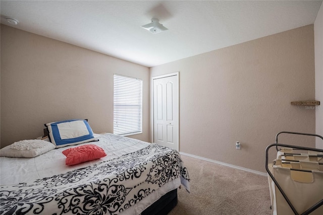 bedroom with a closet, carpet, and baseboards