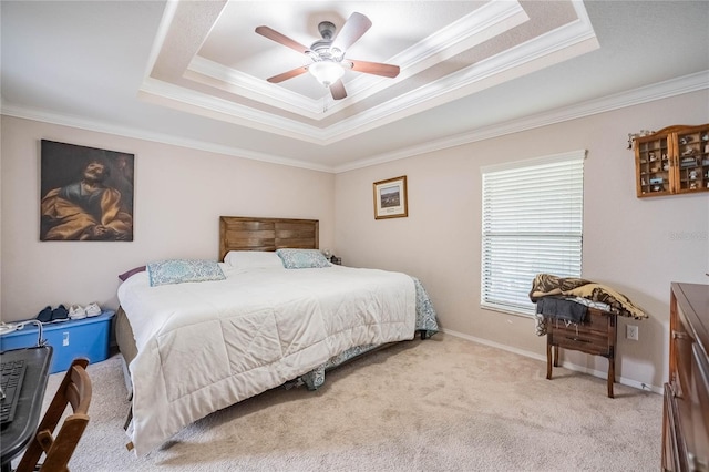 bedroom with ornamental molding, a tray ceiling, light carpet, and baseboards