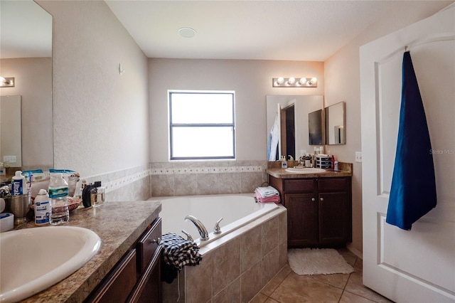 bathroom featuring two vanities, a sink, a bath, and tile patterned floors