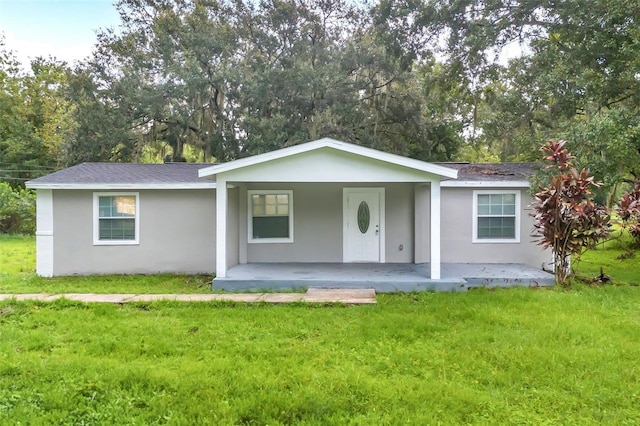 ranch-style home featuring a front lawn and covered porch