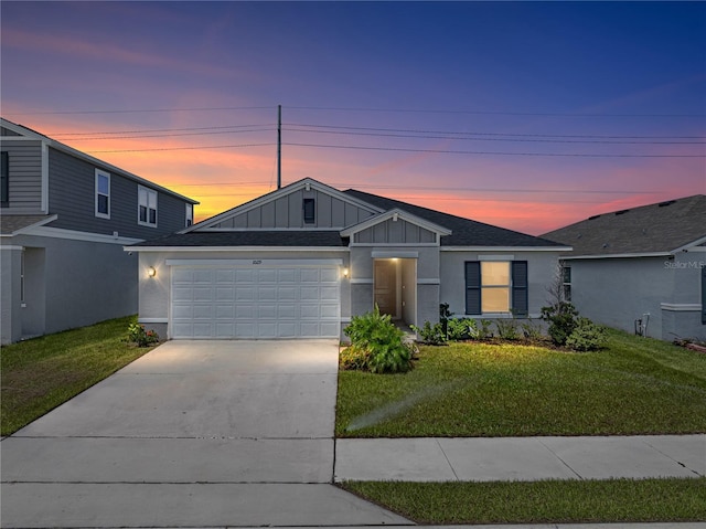 view of front of property with a garage and a lawn