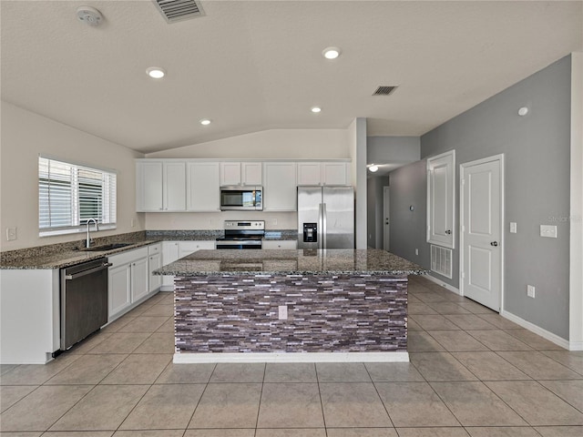 kitchen featuring white cabinetry, sink, stainless steel appliances, and a kitchen island