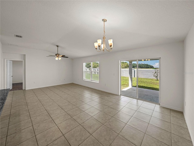 tiled spare room featuring ceiling fan with notable chandelier, a textured ceiling, and vaulted ceiling