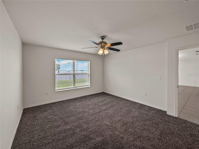 carpeted empty room featuring a textured ceiling and ceiling fan