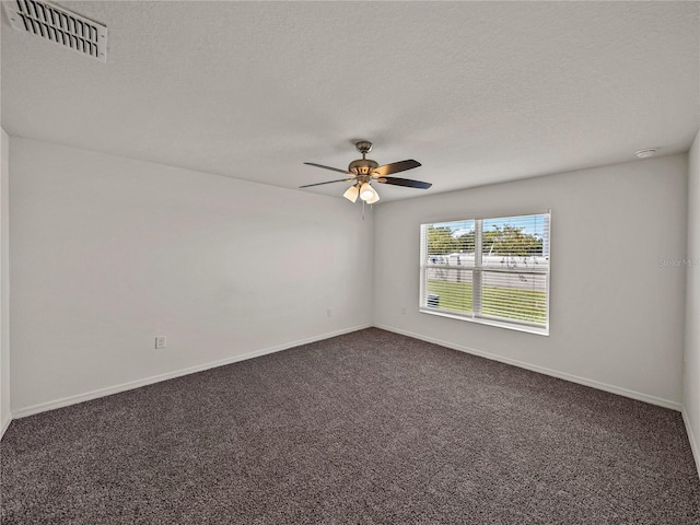 empty room with ceiling fan, dark carpet, and a textured ceiling