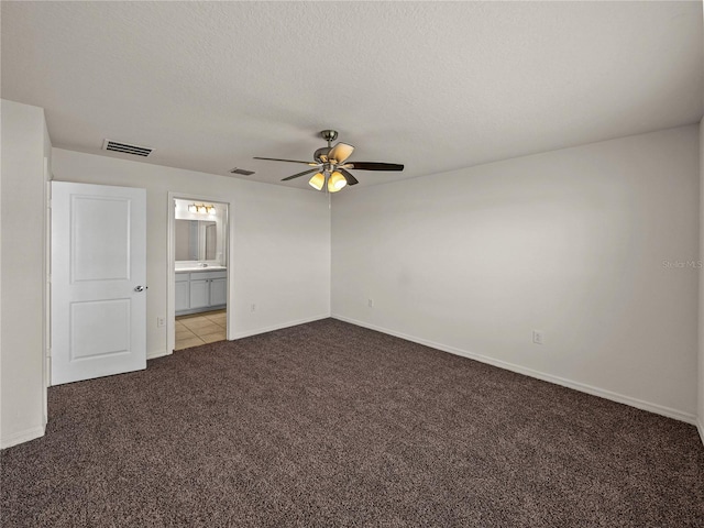 unfurnished bedroom featuring ceiling fan, ensuite bath, light carpet, and a textured ceiling