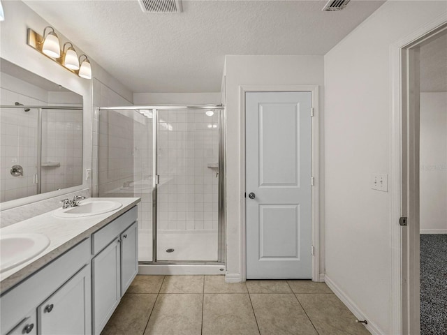 bathroom featuring a textured ceiling, walk in shower, tile patterned floors, and vanity