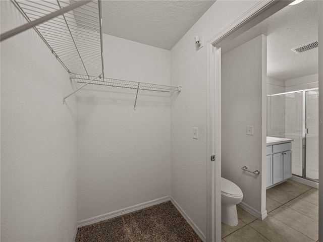 spacious closet featuring light tile patterned floors