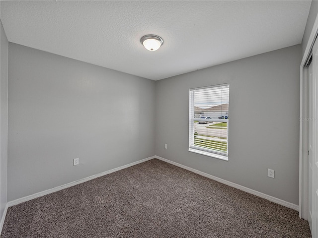 carpeted spare room featuring a textured ceiling