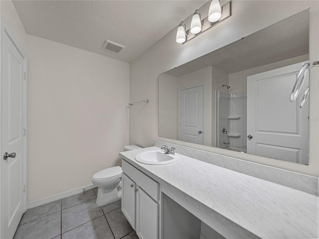 bathroom with a textured ceiling, toilet, tile patterned flooring, and vanity