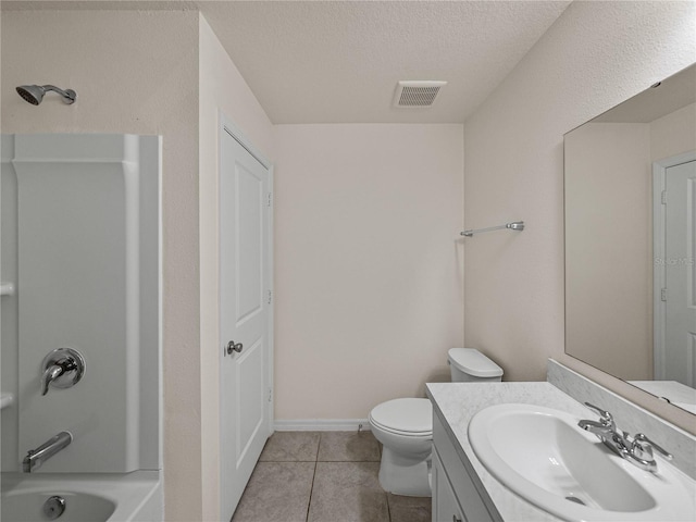 full bathroom with a textured ceiling, tile patterned floors, vanity, washtub / shower combination, and toilet