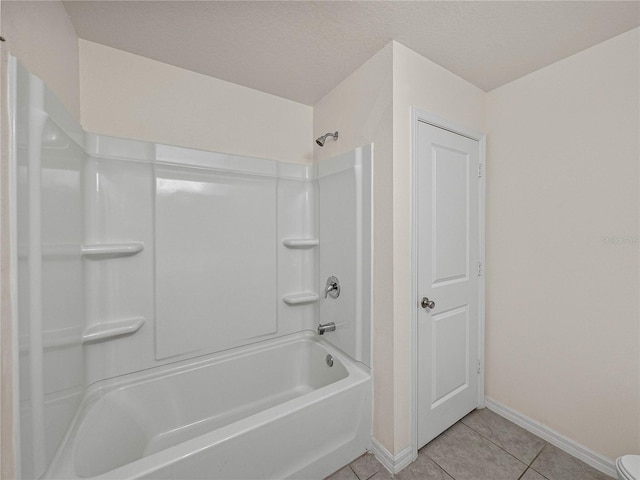 bathroom with tile patterned floors, a textured ceiling, and washtub / shower combination