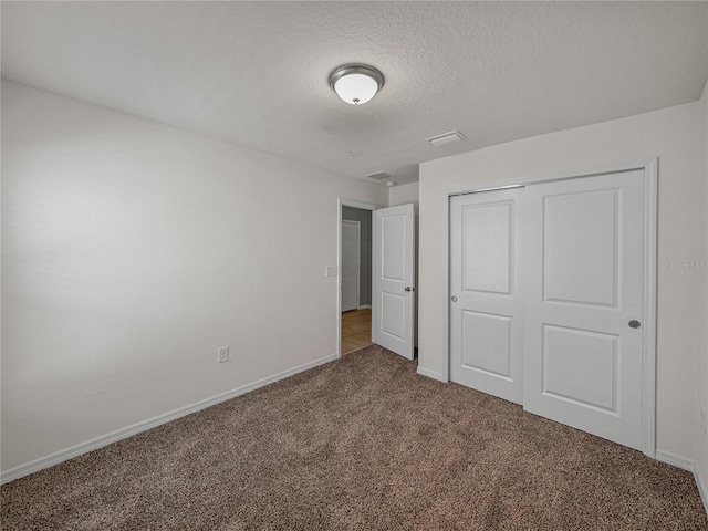 unfurnished bedroom with carpet floors, a closet, and a textured ceiling