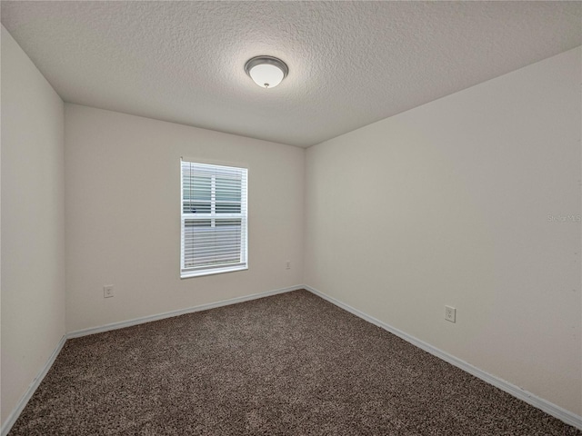 empty room with a textured ceiling and carpet flooring