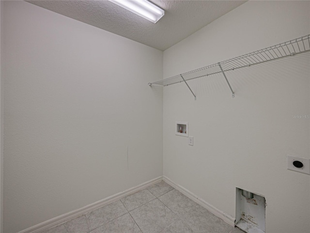 laundry room with a textured ceiling, hookup for a washing machine, and electric dryer hookup